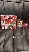 Photo of three Coca-Cola themed items: coaster set, playing cards with polar bear collectible, and red Coca-Cola yo-yo with string.