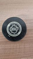 Top view of black hockey puck with NHL logo and official licensed product text.
