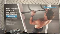 Front side of the box showing product usage with an image of a man performing pull-ups, the Iron Body brand, and key features like multi-function design and maximum load.