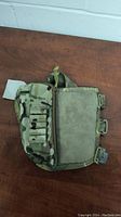 Front view of camouflage tactical army pouch showing flap, snap button, loop panels, and compact design.