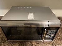 Front view of Cuisinart microwave showing door and handle with brand name.
