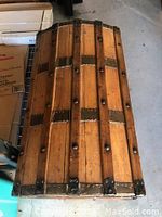 Top view of wooden humpback trunk showing vertical wooden slats and metal bands with rivets.
