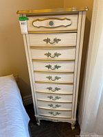 Front view of tall lingerie chest showing 5 drawers with ornate handles and gold trim.
