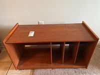 Full front view of the wood entertainment unit showing three vertical dividers inside.