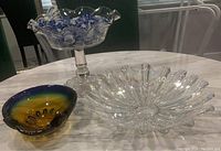 Photo showing three glass items: Murano glass dish, clear pressed glass pedestal bowl, and iridescent carnival glass dish