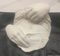 Front view of the white torso sculpture with two hands, showing detailed textures and features.