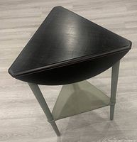 Triangular configuration showing the three legs, black wooden top with drop-down sections, and gray triangular bottom shelf.