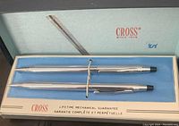 Chrome Cross pen and pencil set in original box with blue felt lining, showing lifetime mechanical guarantee text.