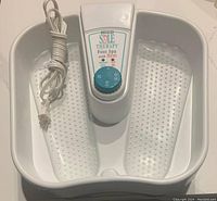 Full view of white Homedics Sole Therapy Foot Spa with textured foot beds, control panel and power cord wrapped.