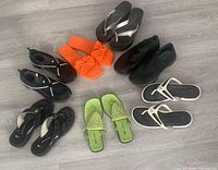 Lot of seven pairs of women's shoes in size 10M arranged on floor.