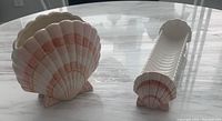 Shell design ceramic napkin holder and cracker tray on marble table showing size and shape.