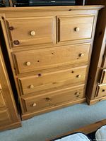 Front view of the pine dresser showing the two small top drawers and three large bottom drawers with round wood knobs.