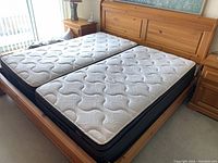 Assembled bed frame with twin mattresses for size reference; pine rails and frame visible