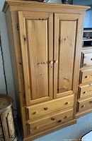 Front view of the solid pine wood wardrobe showing two panel doors and two drawers below.