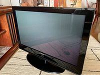 Front view of Samsung 42-inch plasma TV showing screen and bezel, placed on carpet, in good physical condition.