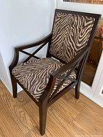 Front angle showing full chair with dark wood frame and zebra print upholstery on seat and back.