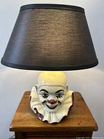 Full frontal view of the lamp showing clown head base and shade