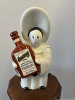 Photo showing the front of the white porcelain Pierrot clown decanter holding a brown Cointreau liquor bottle with detailed label.