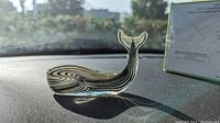 Front side view of clear lucite whale on dashboard under sunlight