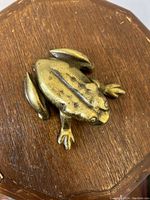 Top view of solid brass frog showing detailing and hinge on the back for opening.