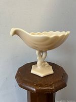 Full front view of the Westmoreland Alacite glass seashell compote showing the scalloped edges and dolphin/serpent stem base.