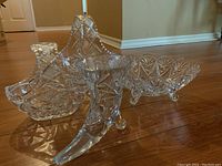 Photo showing the crystal boot-shaped vase, footed bowl, and two baskets from an angled view