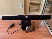 Front view of Vizio soundbar resting on wireless subwoofer with all cables and quick start guide on floor.