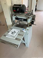 Front view of Delta planer on stand showing infeed and outfeed tables