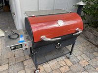 Full shot of barrel-style pellet grill with digital control panel and power cord