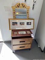 Overall view showing side table, mirror, framed pictures, and coat rack stacked together