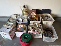 Full view of multiple boxes containing Spode Christmas Holiday dinnerware, holiday lighting, snowman decor, and assorted decorations.