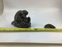 Photo of two small animal sculptures side by side with measuring tape showing length, larger beaver sculpture and smaller frog sculpture.