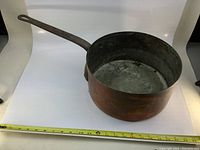 Large copper pot with handle shown from the side on white background