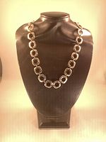 Full view of cushion link necklace on black bust stand