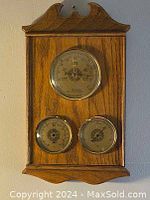 Front view of French barometer with solid wooden frame, showing three metal-ringed round dials with glass covers on a wood background with decorative top and bottom edges