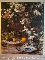 Detailed view of the floral still life oil painting showing white flowers in a basket, fruits, pitcher, and plate on a table surface.