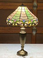 Full view of the Tiffany style lamp showing stained glass shade and brass finish base.