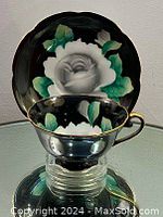 Teacup placed on the saucer showing floral design and gold trim