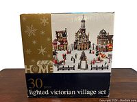 Box showing the 30-piece lighted Victorian village set with image of assembled village on front.