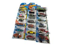 Full lot shot showing all Hot Wheels and Matchbox cars in original packaging arranged in rows on white background