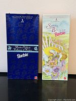 Both Barbie doll boxes side by side: Winter Velvet in dark blue box and Spring Blossom in pastel floral box.
