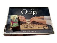 Top view of Ouija board box with Tarot card deck placed on top showing both items in lot.