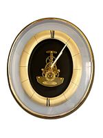 Full front view of the gold oval Seiko wall clock showing dial and skeleton movement.