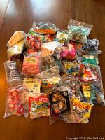 All 26 vintage McDonalds promotional toys laid out on table, mostly in original sealed plastic packaging, showing quantity and packaging condition.