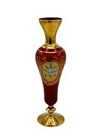 Full view of the tall ruby red Bohemian glass vase with gold rim and base.