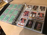 Open binder showing both front and back of hockey cards including player portraits and stats on back