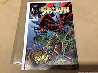 Photo of Spawn comic book issue #11 showing the cover with the Todd McFarlane signature.