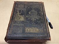 Front cover of the antique book showing the embossed and gilded title 'The Royal History of England' with decorative imagery.