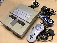 Super Nintendo console top view showing power and reset buttons and eject slot, yellowed with age