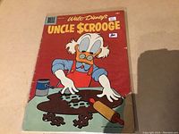 Front cover of Uncle Scrooge issue #14 showing Uncle Scrooge rolling dough shaped as dollar signs, with Dell and Walt Disney branding and price of 10 cents.